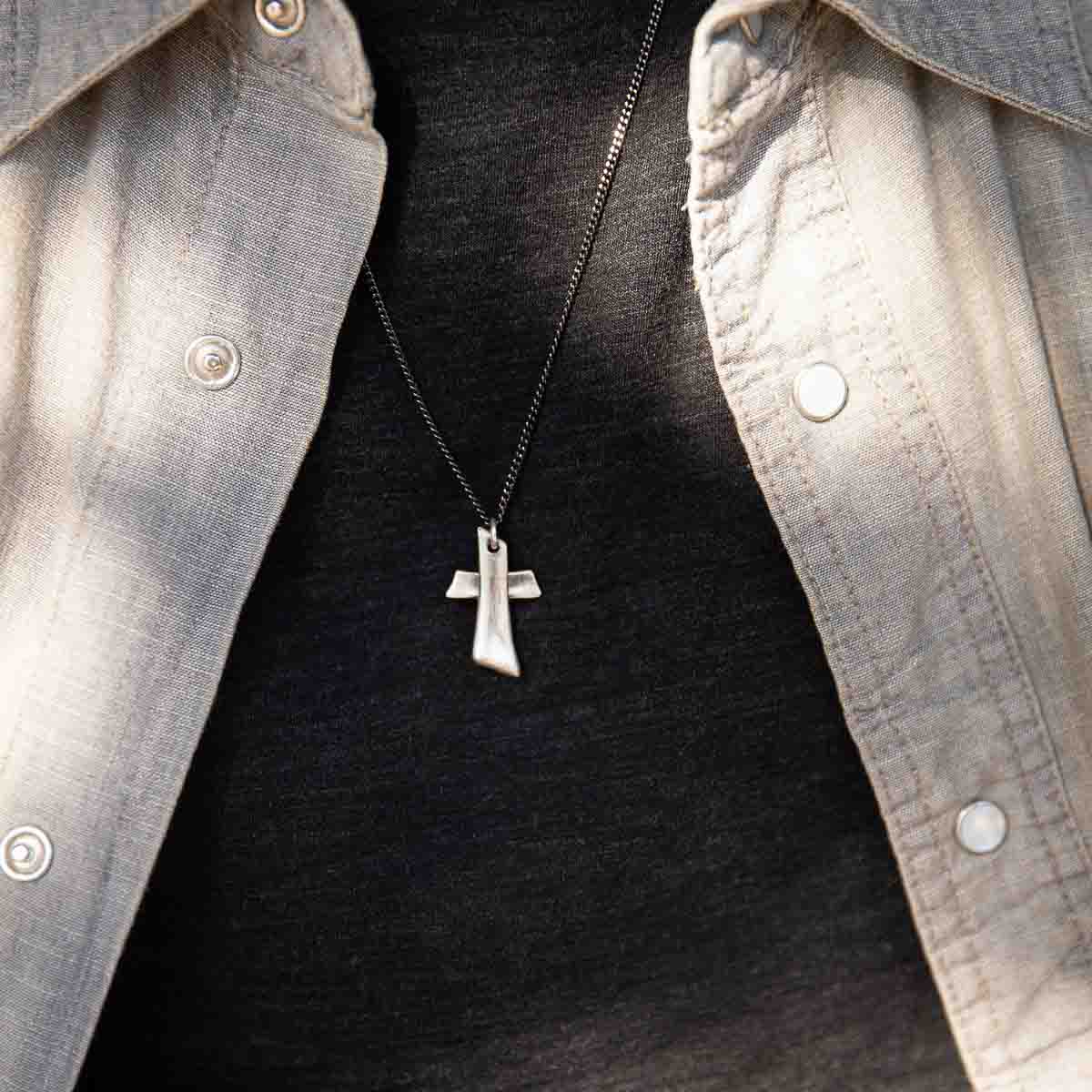 Man wearing Accord Cross necklace handcrafted in antiqued sterling silver with the pendant strung on your choice of chain