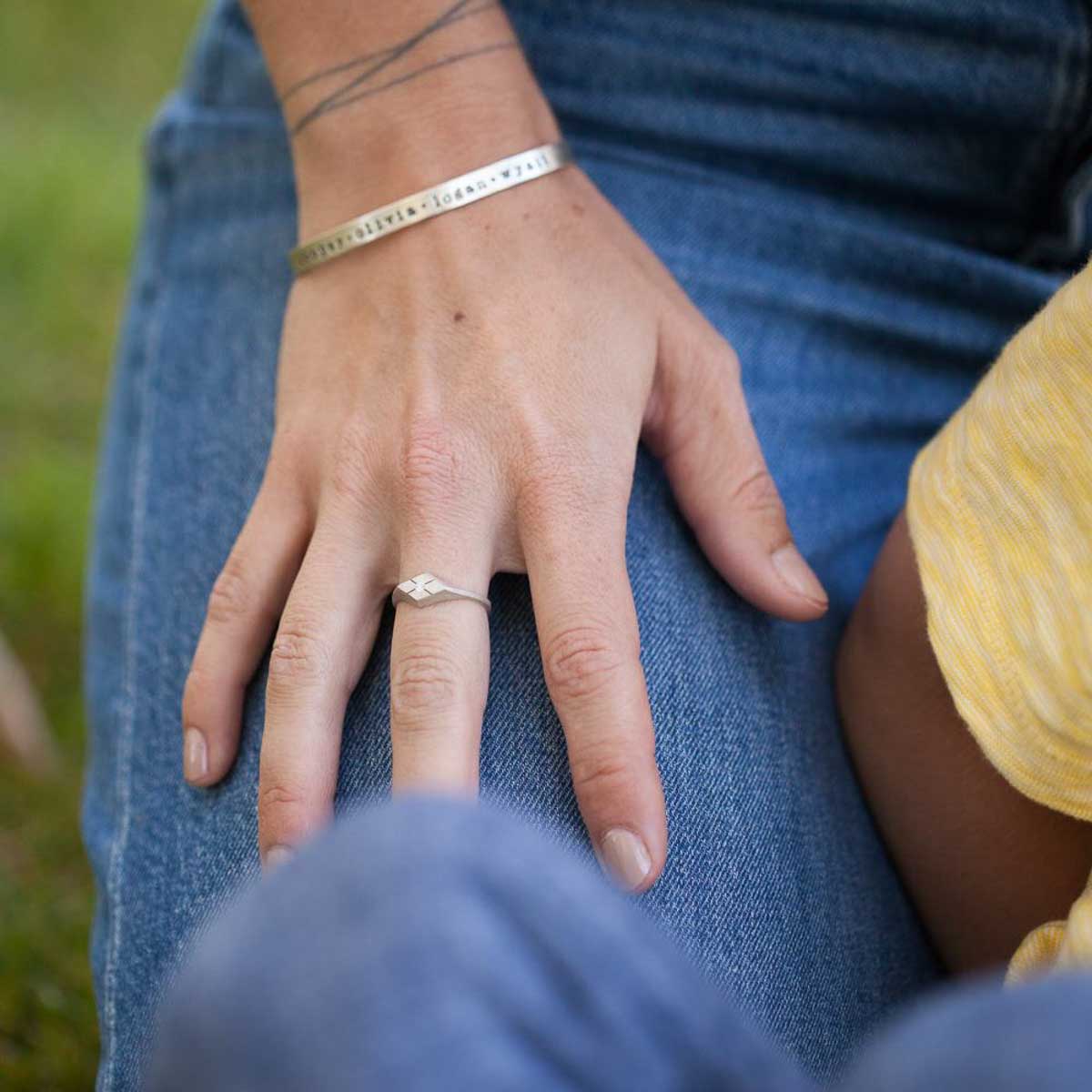 Girl wearing Adored ring hand-molded and cast in sterling silver set with a 2mm genuine diamond along with other sterling silver jewelry