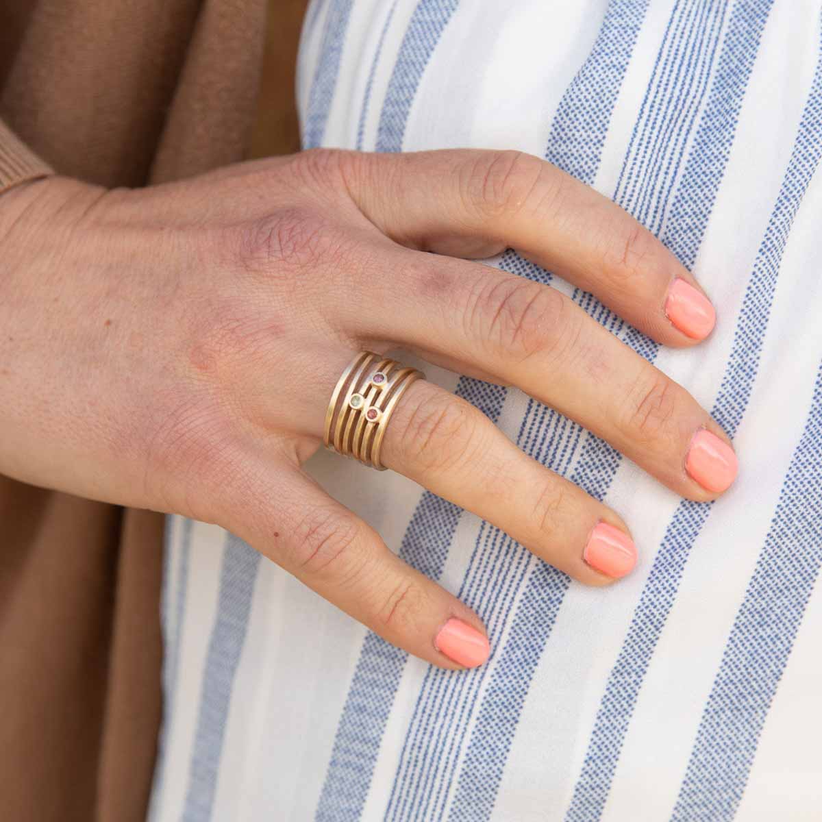 Woman wearing Always together birthstone ring handcrafted in 10k yellow gold set with 3 to 6 birthstones