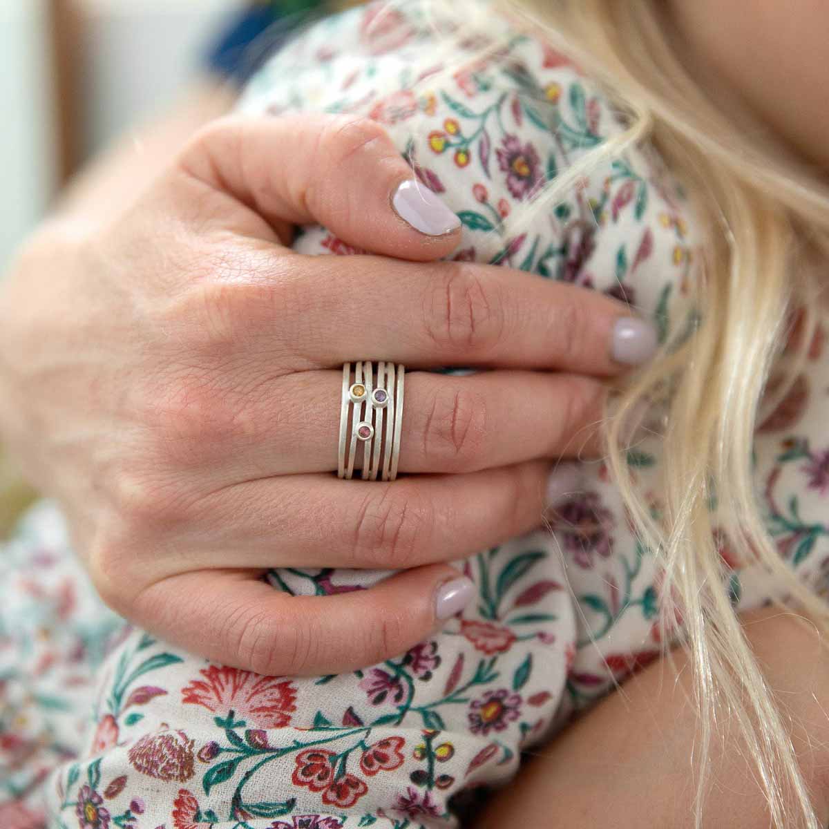 Girl wearing Always together birthstone ring handcrafted in sterling silver set with 3 to 6 birthstones with her daughter