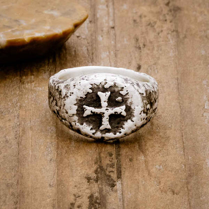 Ancient Cross Signet Ring, handcrafted in sterling silver, sitting on a wood background 