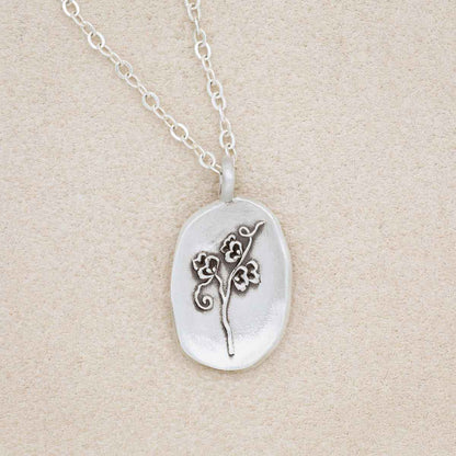 sterling silver April Birth flower necklace, on beige background