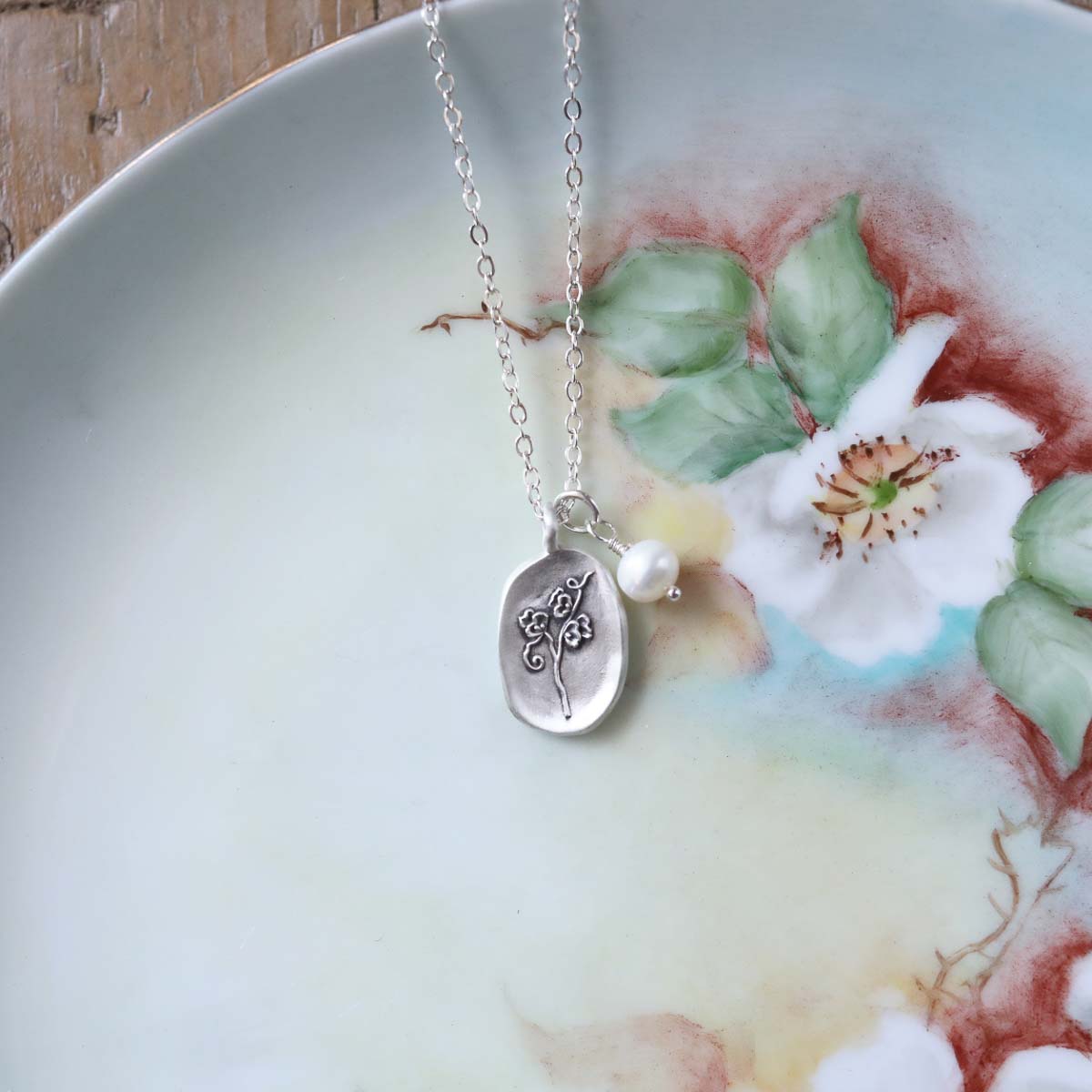 April birth flower necklace handcrafted in sterling silver with a special birth month charm strung with a vintage freshwater pearl