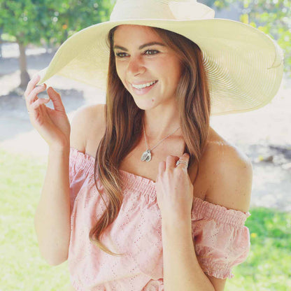 Girl wearing her April birth flower necklace handcrafted in sterling silver with a special birth month charm strung with a vintage freshwater pearl