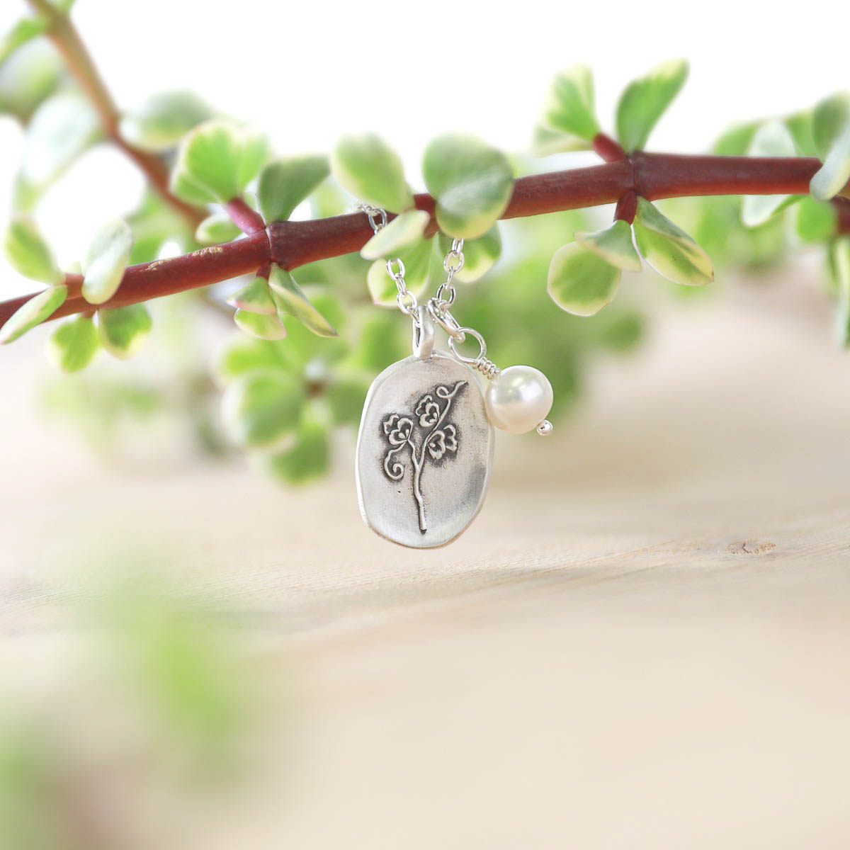 April birth flower charm handcrafted in sterling silver with a special birth month charm strung with a vintage freshwater pearl