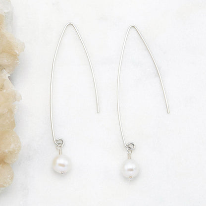 sterling silver artisan pearl earrings on marble background