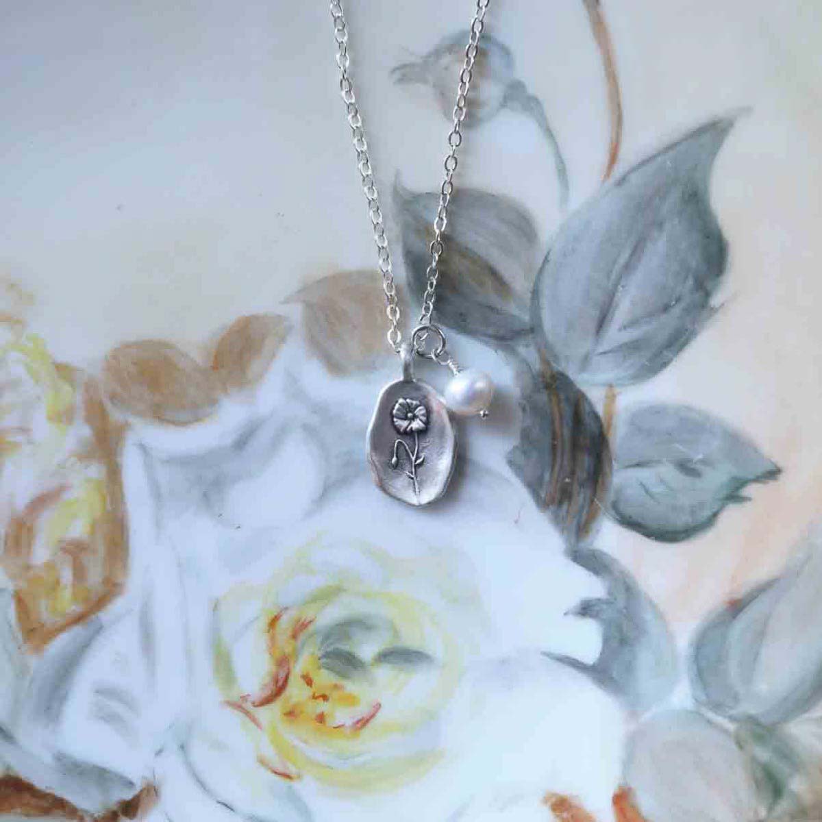 August birth flower necklace handcrafted in sterling silver with a special birth month charm strung with a vintage freshwater pearl