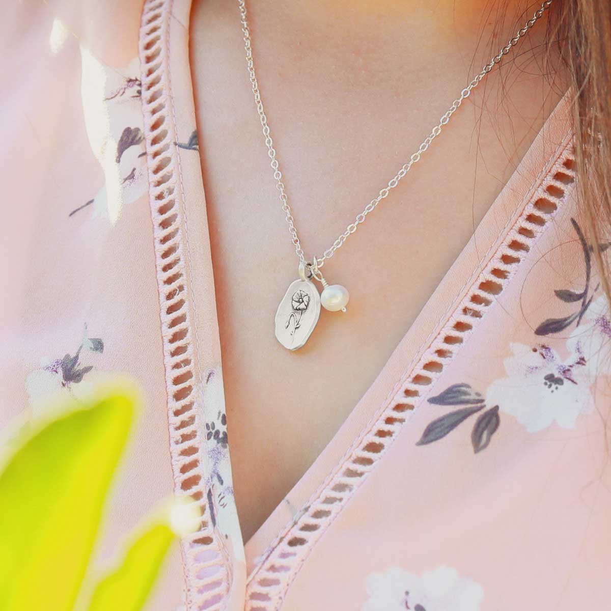 Girl wearing her August birth flower necklace handcrafted in sterling silver with a special birth month charm strung with a vintage freshwater pearl