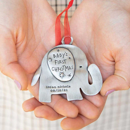 hand holding a baby's first Christmas ornament of an elephant hand-molded and cast in fine pewter. personalized with up to two lines with a name, phrase or date being 