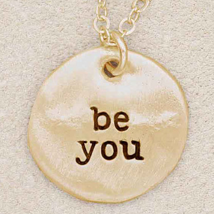 Girl wearing her Be you disc necklace handcrafted in 10k gold personalized with engraved names