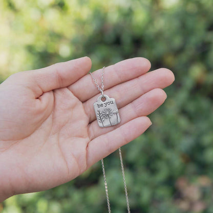 Be you necklace handcrafted in pewter hung on a silver-toned link chain with the words "be you" engraved