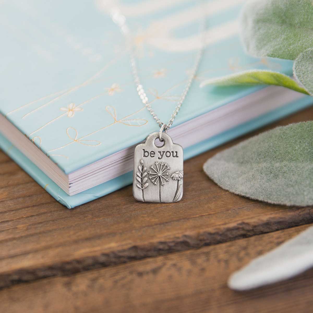 Be you necklace handcrafted in pewter hung on a silver-toned link chain with the words "be you" engraved