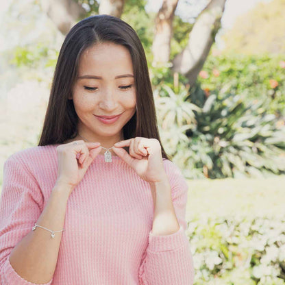 Girl wearing her Be you necklace handcrafted in pewter hung on a silver-toned link chain with the words "be you" engraved