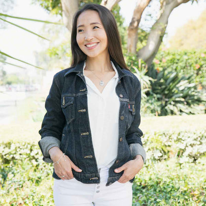 Girl wearing her Be you necklace handcrafted in pewter hung on a silver-toned link chain with the words "be you" engraved