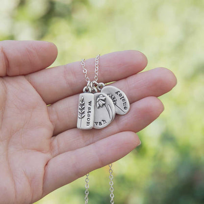 Personalized sterling silver be you wildflowers necklace with 3 sterling silver charms on display