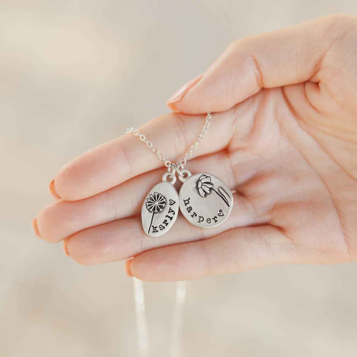 Girl holding her Personalized sterling silver be you wildflowers necklace 