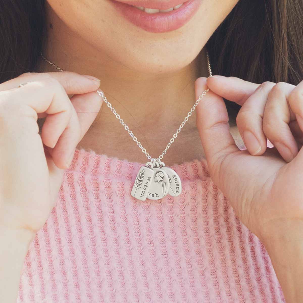 Girl wearing her Personalized sterling silver be you wildflowers necklace with 3 sterling silver charms