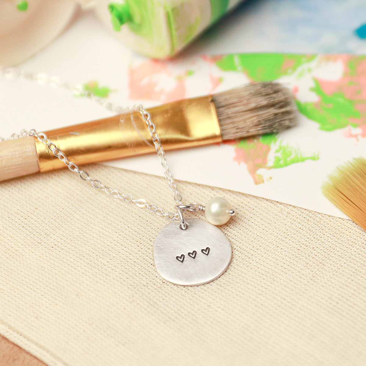 Beloved name disc handcrafted in sterling silver hung with a vintage freshwater pearl and customizable with a name or word