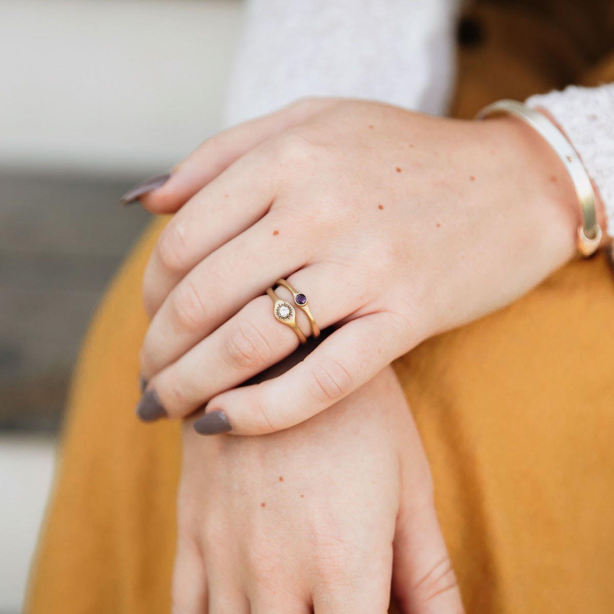 Girl wearing Bezel birthstone ring handcrafted in 10k yellow gold set with a 3mm birthstone inside a gold bezel