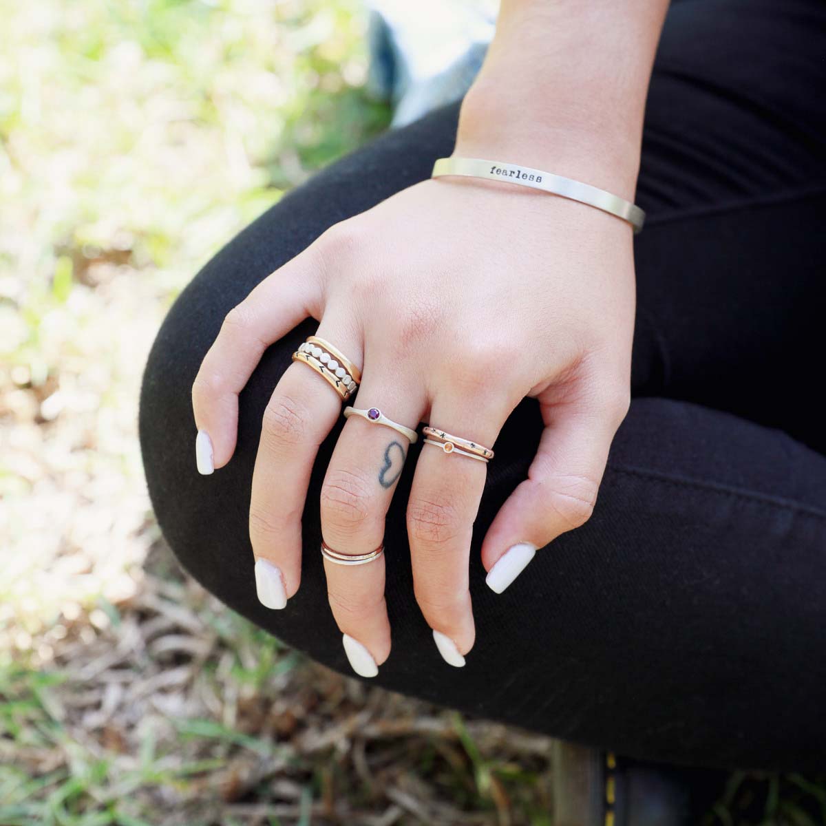 Girl wearing Bezel birthstone ring handcrafted in sterling silver set with a 3mm birthstone inside a sterling bezel along with other jewelry