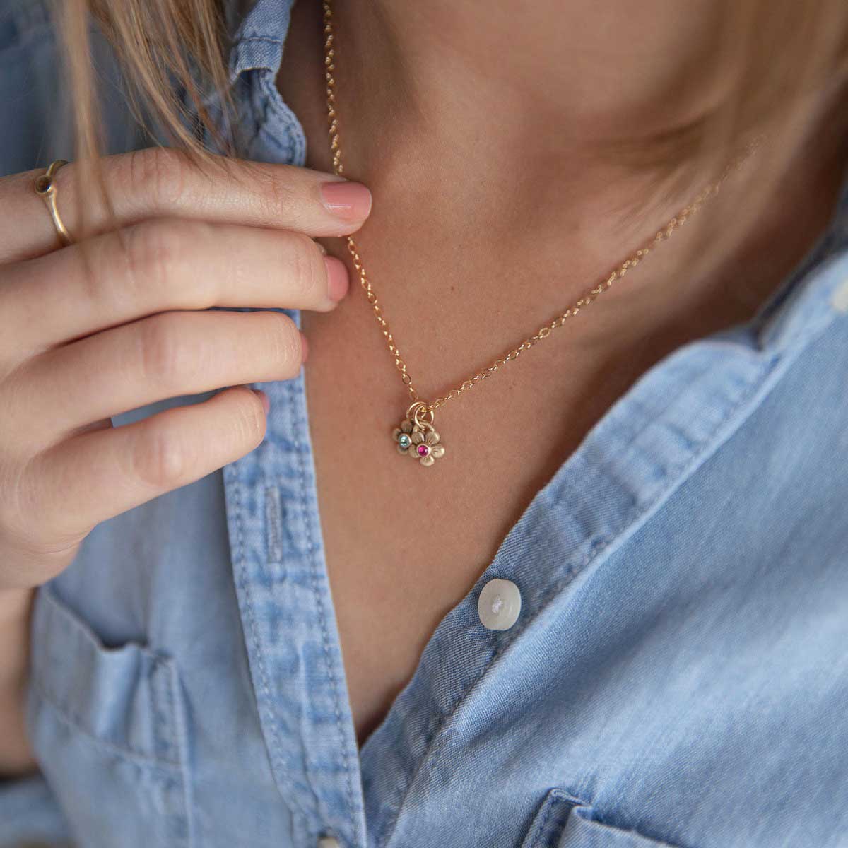 girl wearing 10k yellow gold birthstone bloom necklace with flower charms containing 2mm genuine birthstones 