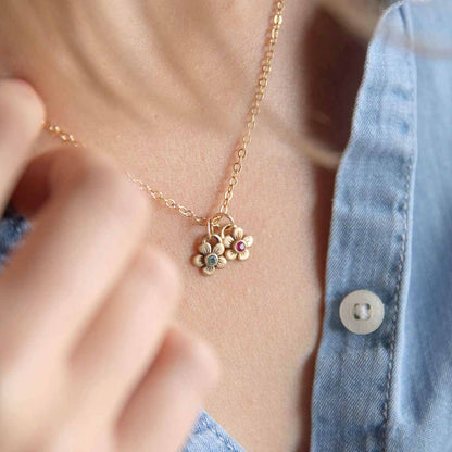 girl wearing 10k yellow gold birthstone bloom necklace with flower charms containing 2mm genuine birthstones 