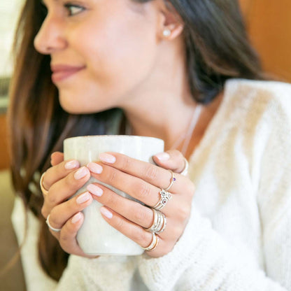 Girl wearing Birthstone bloom ring  handcrafted in sterling silver with an antiqued/satin finish set with a 2mm birthstone along with other sterling silver jewelry