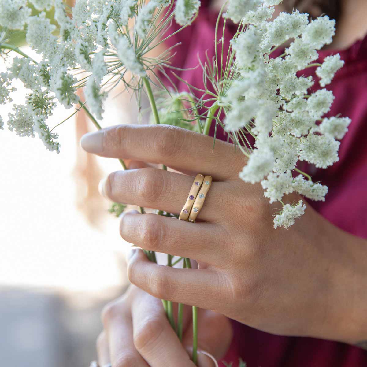 Girl wearing her Stackable birthstone rings handcrafted in 10k yellow gold with 2mm birthstones 