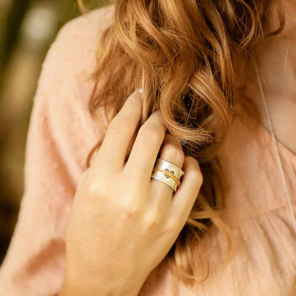 close up of girl wearing brave love® spinner ring {sterling silver & 10k gold}