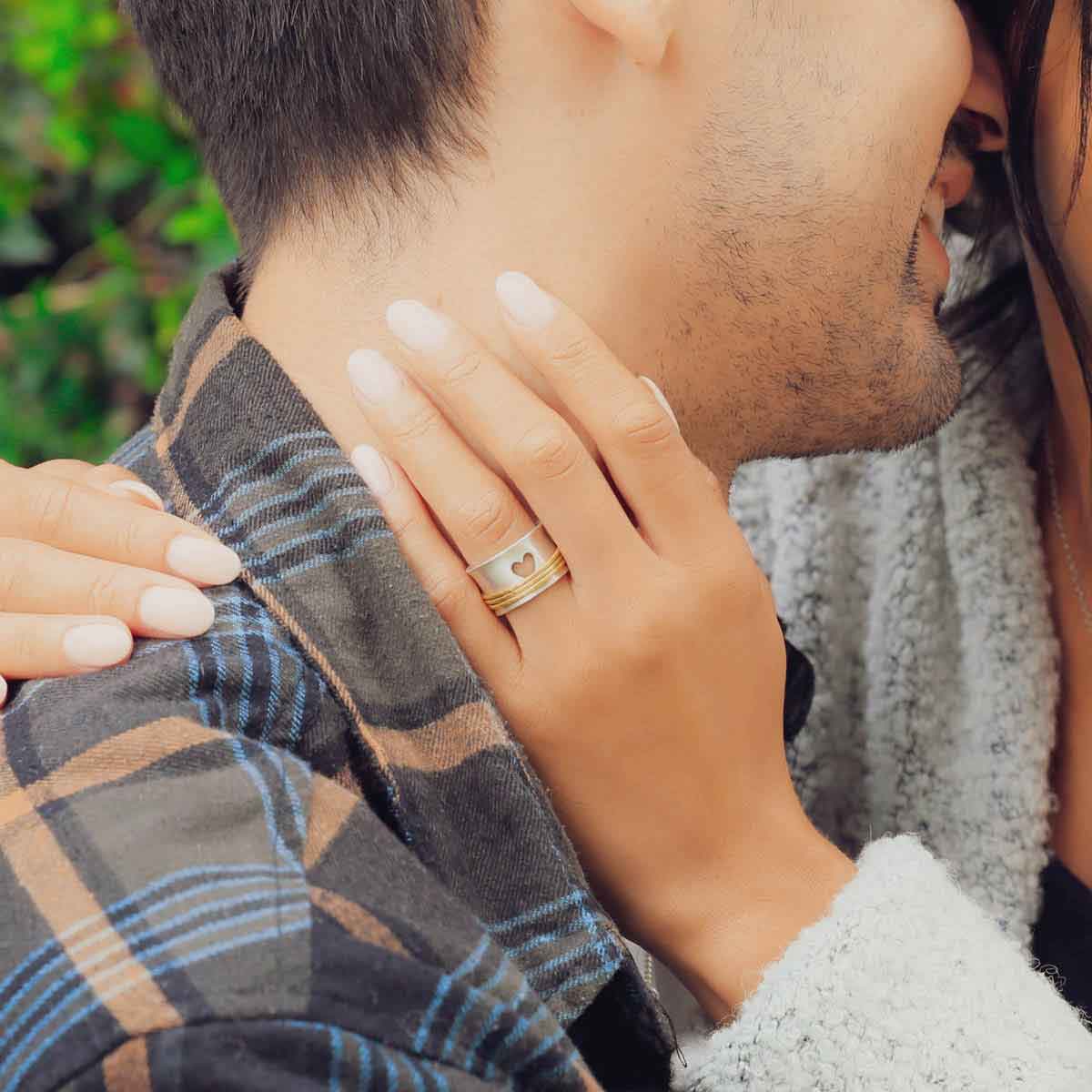 close up of girl wearing brave love spinner ring gold hugging boyfriend