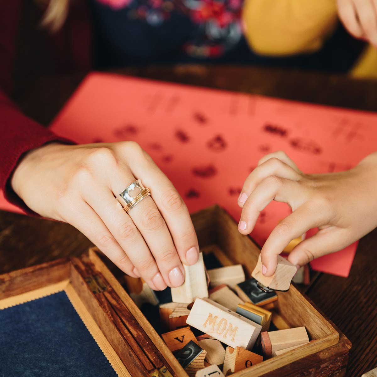 Woman wearing Brave Love spinner ring with a sterling silver band and gold-filled spinners and engraved with "brave love" on the inside