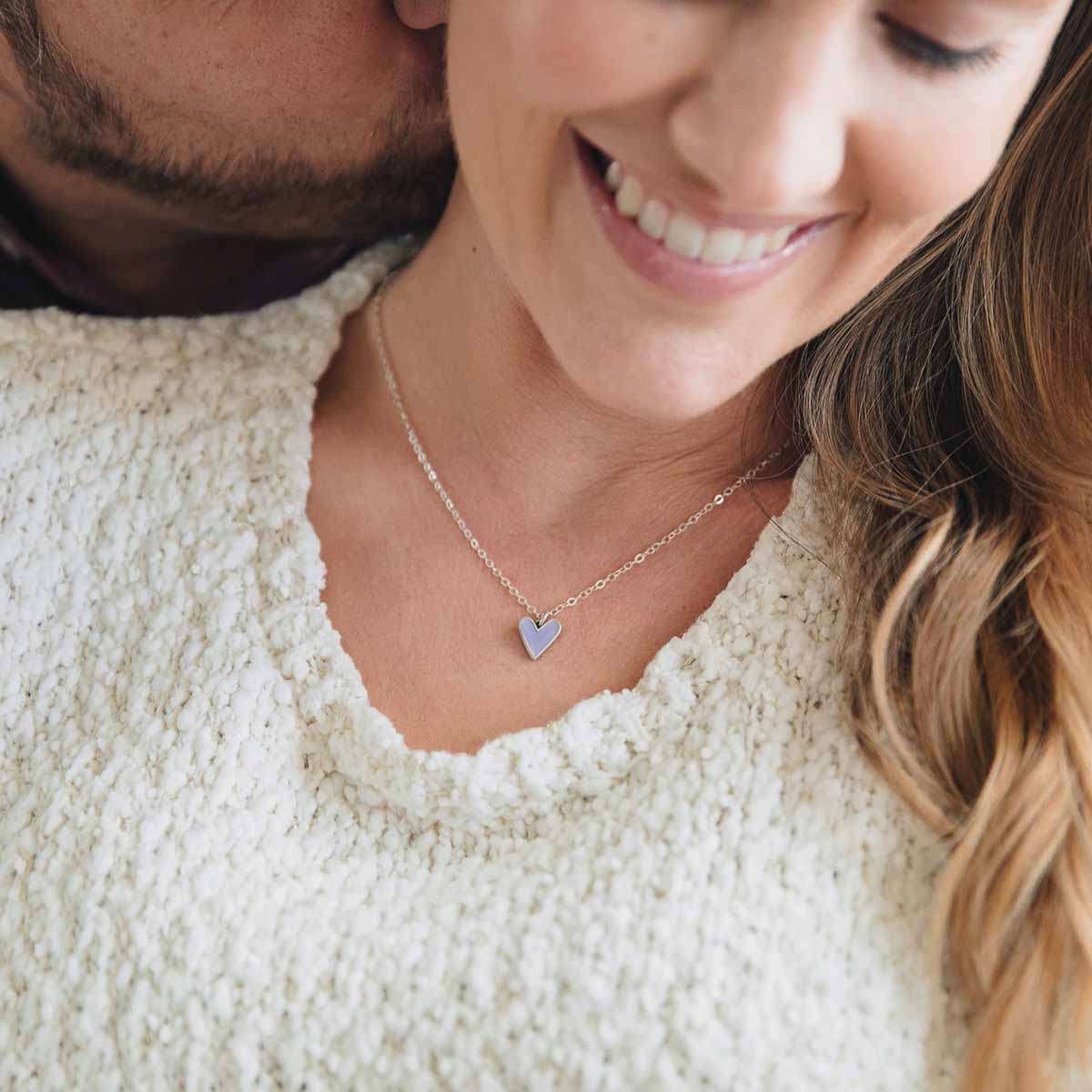 Girl wearing her Brave Love tiny heart necklace handcrafted in sterling silver with choice of color epoxy