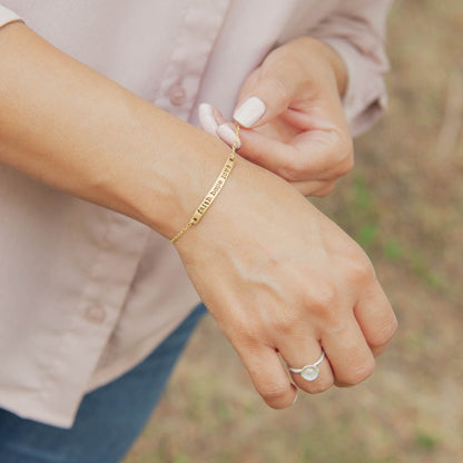 Woman showing her personalized carry my heart 10k yellow gold bracelet with aventurine stone