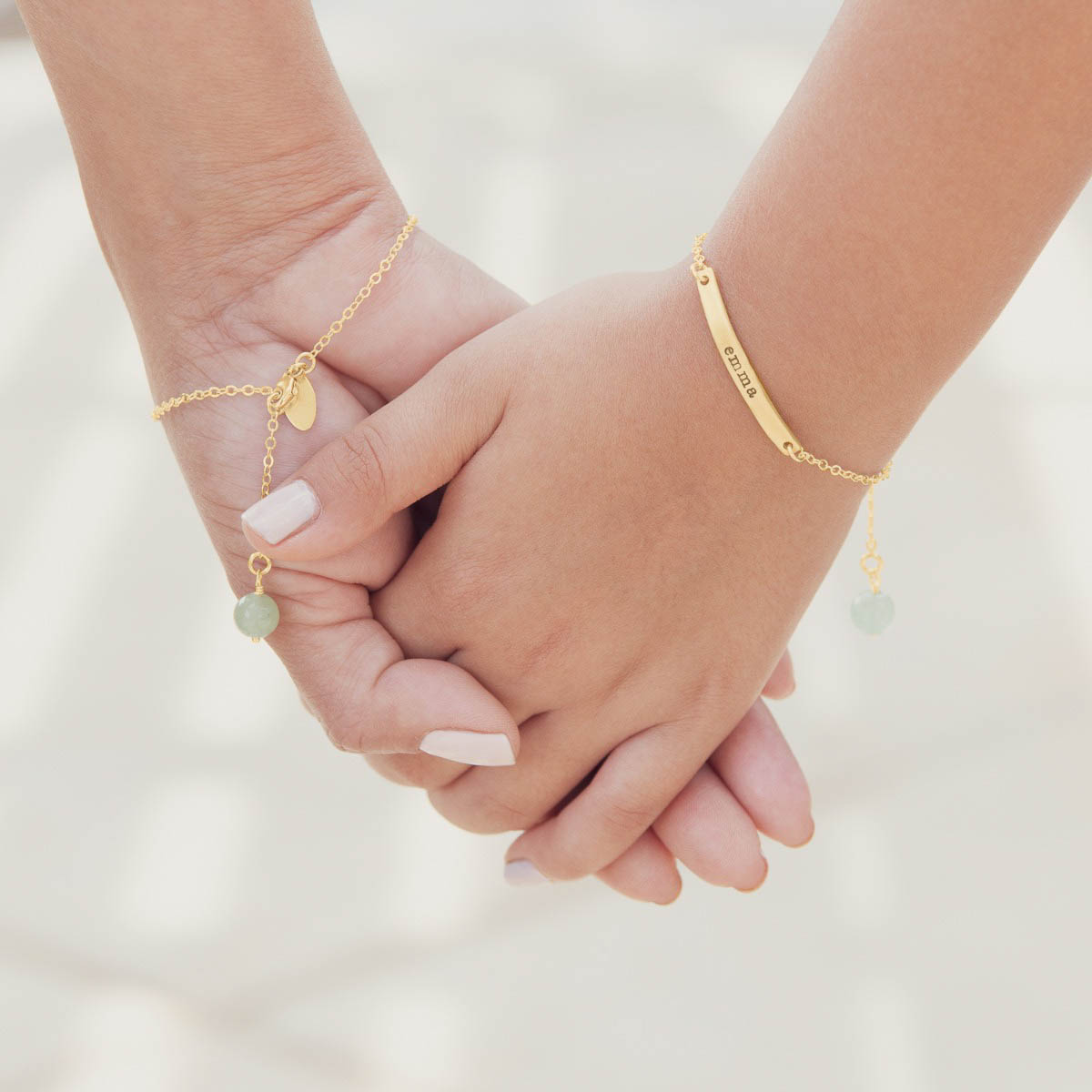 Woman wearing her personalized carry my heart 14k yellow gold bracelet with aventurine stone