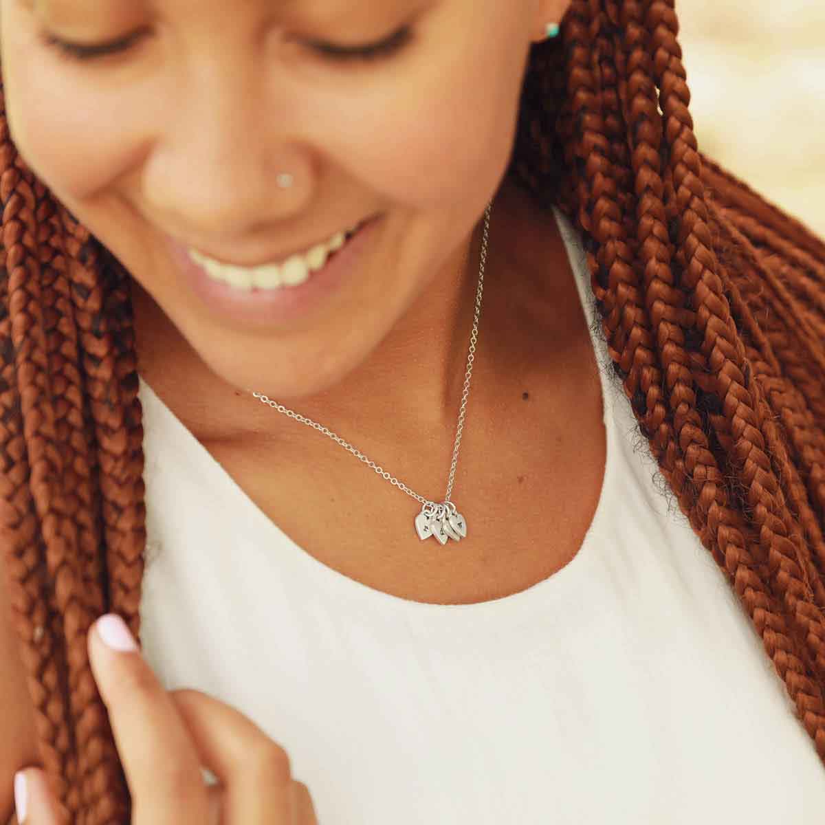 Girl wearing her Cherished hearts initials necklace handcrafted in sterling silver including personalized initial sterling silver charms