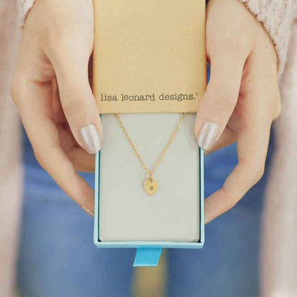 Woman holding her Cherished hearts initials necklace handcrafted in 14k yellow gold with personalized charm