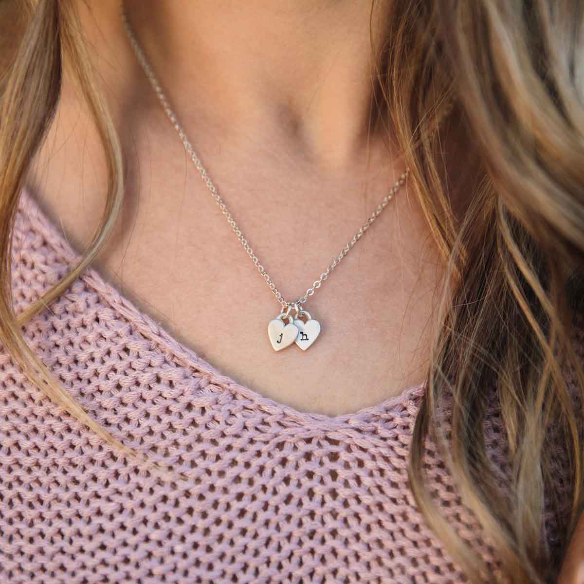 Girl wearing her Cherished hearts initials necklace handcrafted in sterling silver including personalized initial sterling silver charms