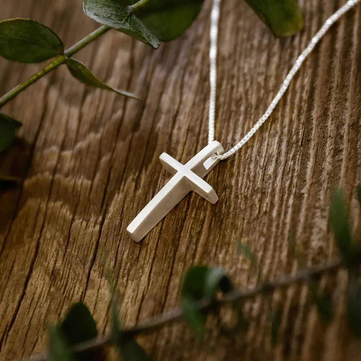 woman holding sterling silver child of faith cross necklace