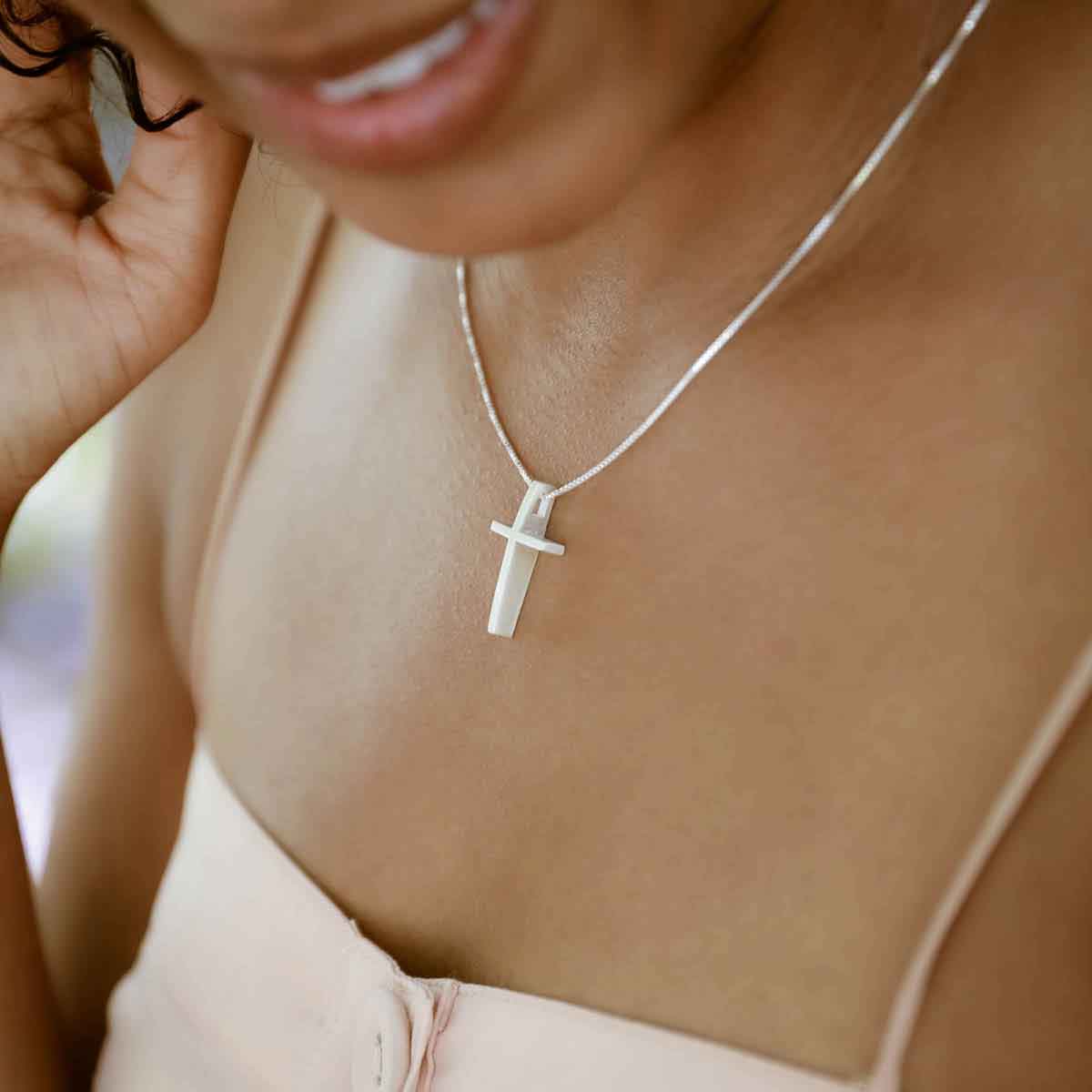 woman holding sterling silver child of faith cross necklace