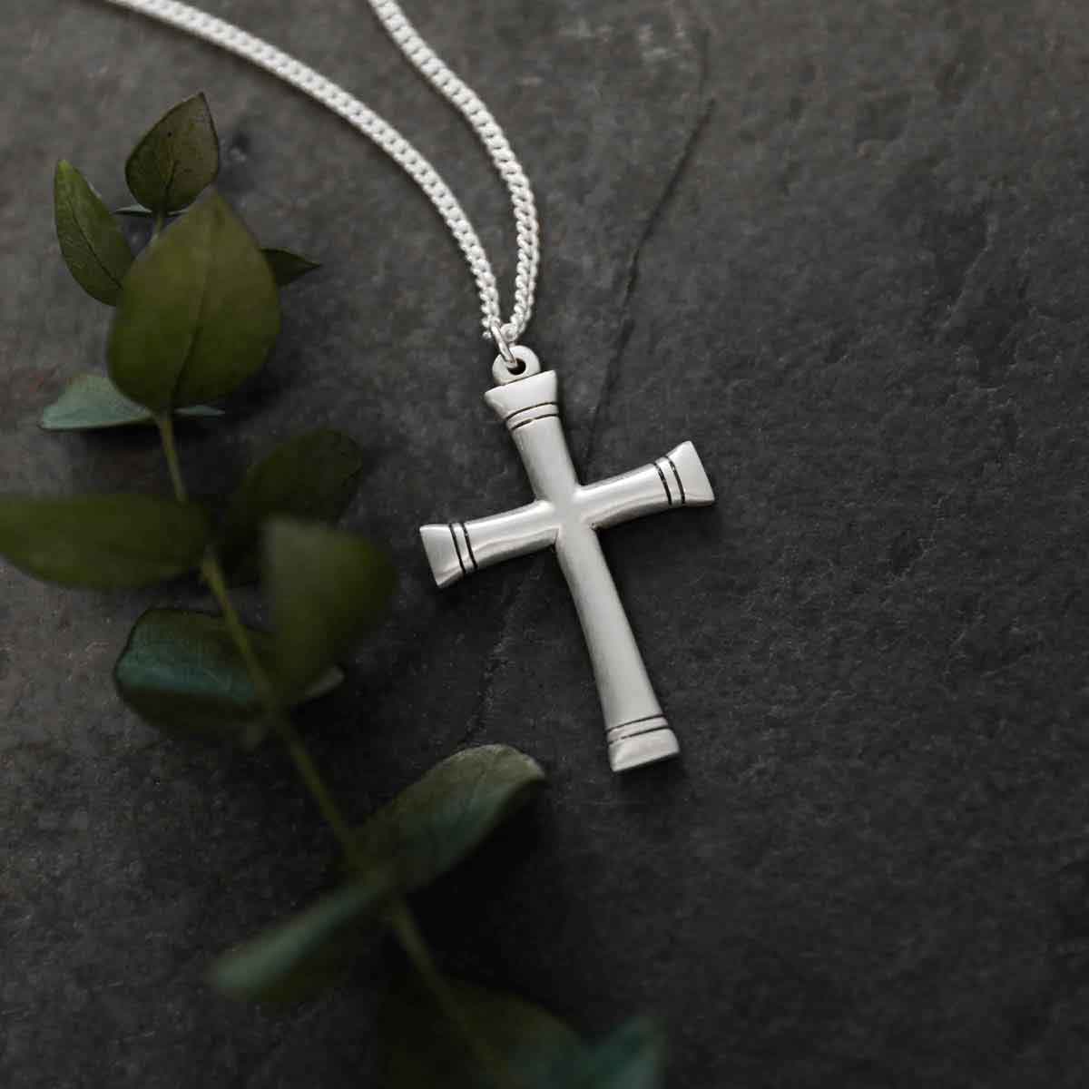 man holding a sterling silver Chosen Cross Necklace