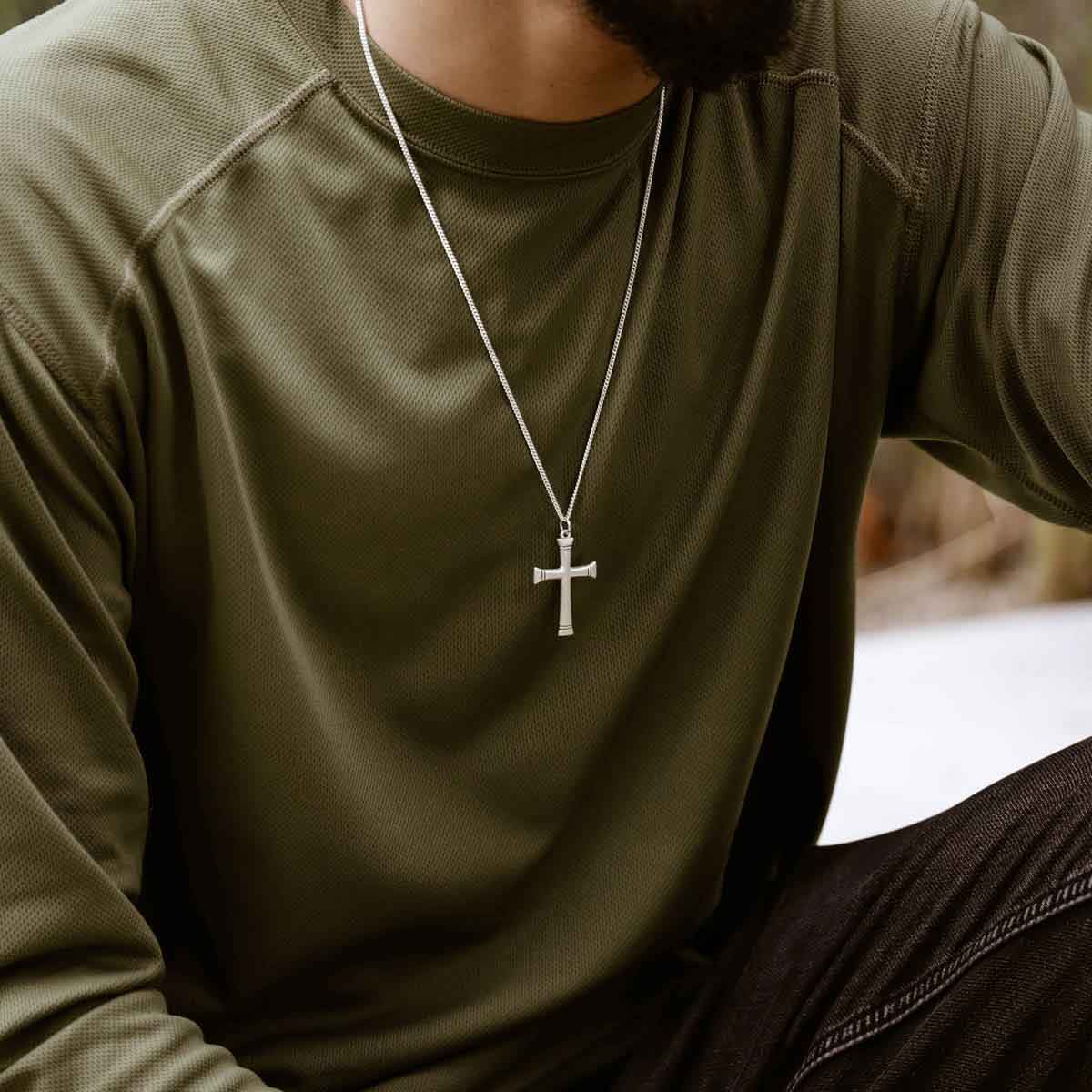 man holding a sterling silver Chosen Cross Necklace