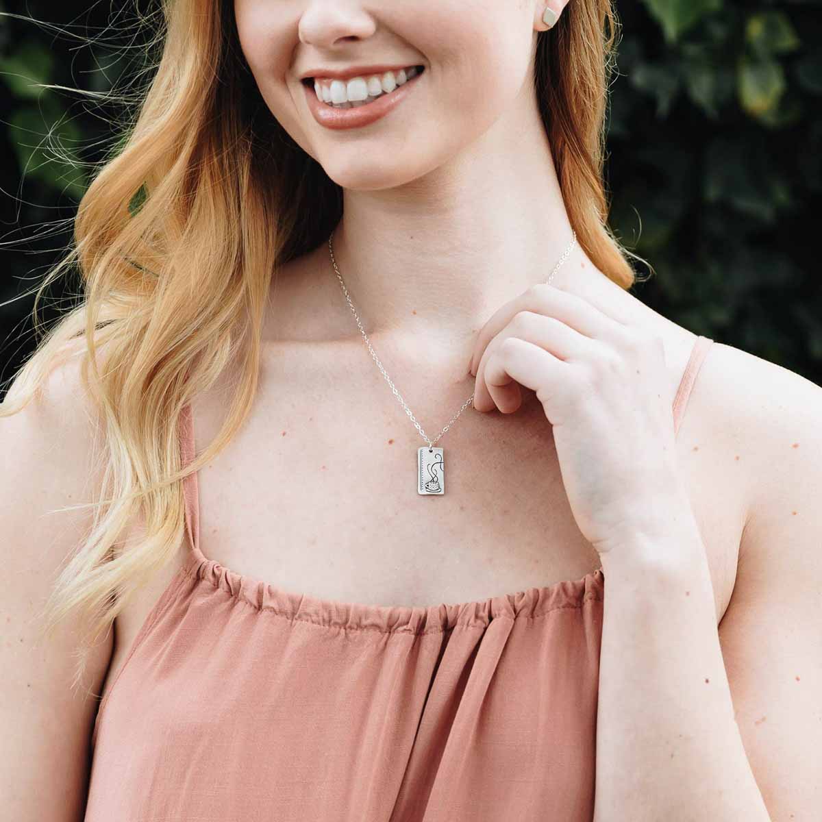 Girl wearing her Coffee and tea necklace set handcrafted in sterling silver with a matte brushed finish with engravings to be connected and shared with someone