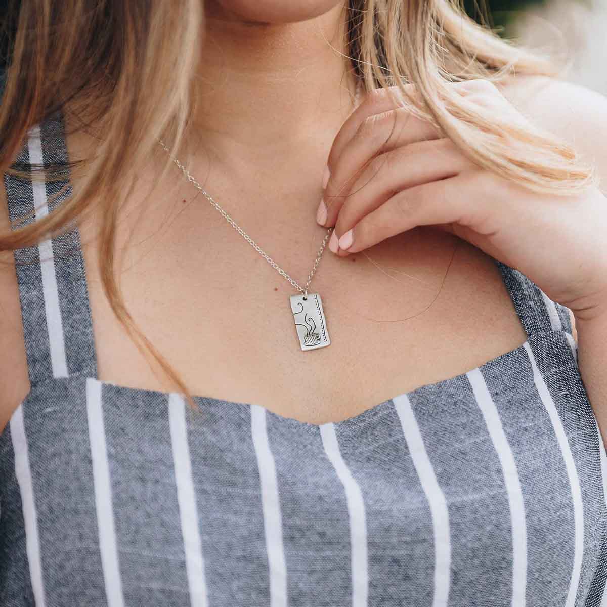 Girl wearing her Coffee and tea necklace set handcrafted in sterling silver with a matte brushed finish with engravings to be connected and shared with someone