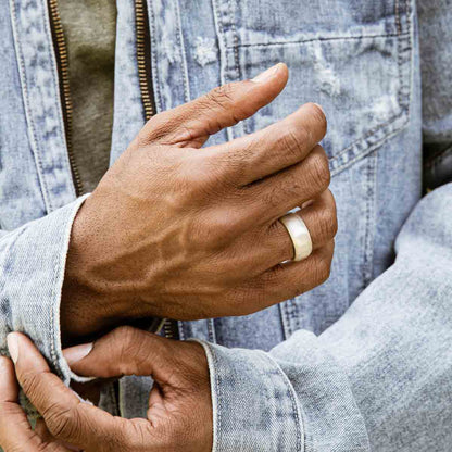 Man wearing Collide with the Sky ring handcrafted in sterling silver with a smooth finish and personalized with a meaningful name