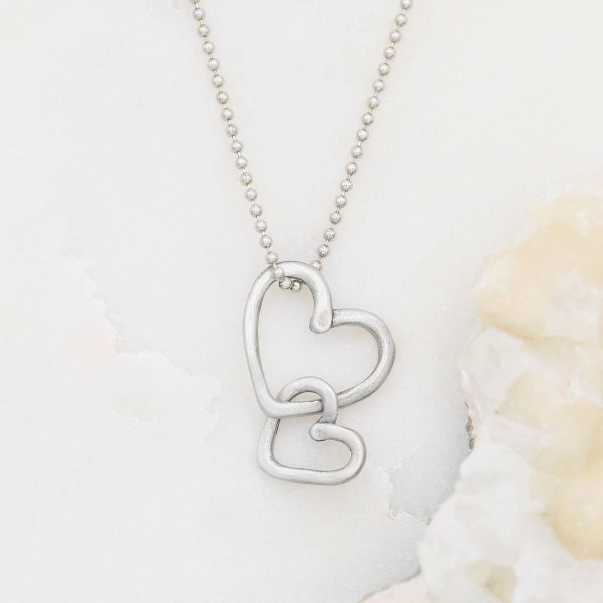 Connected hearts necklace handcrafted in pewter including a pair of heart charms