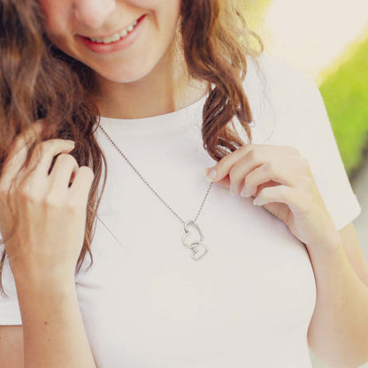 Girl wearing her Connected hearts necklace handcrafted in pewter including a pair of heart charms