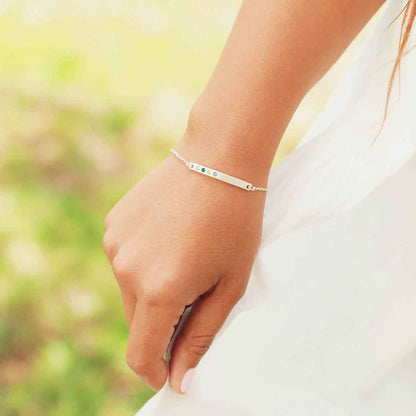 Woman wearing her personalized sterling silver cross bar birthstone bracelet