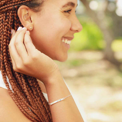 Woman wearing her personalized sterling silver cross bar birthstone bracelet