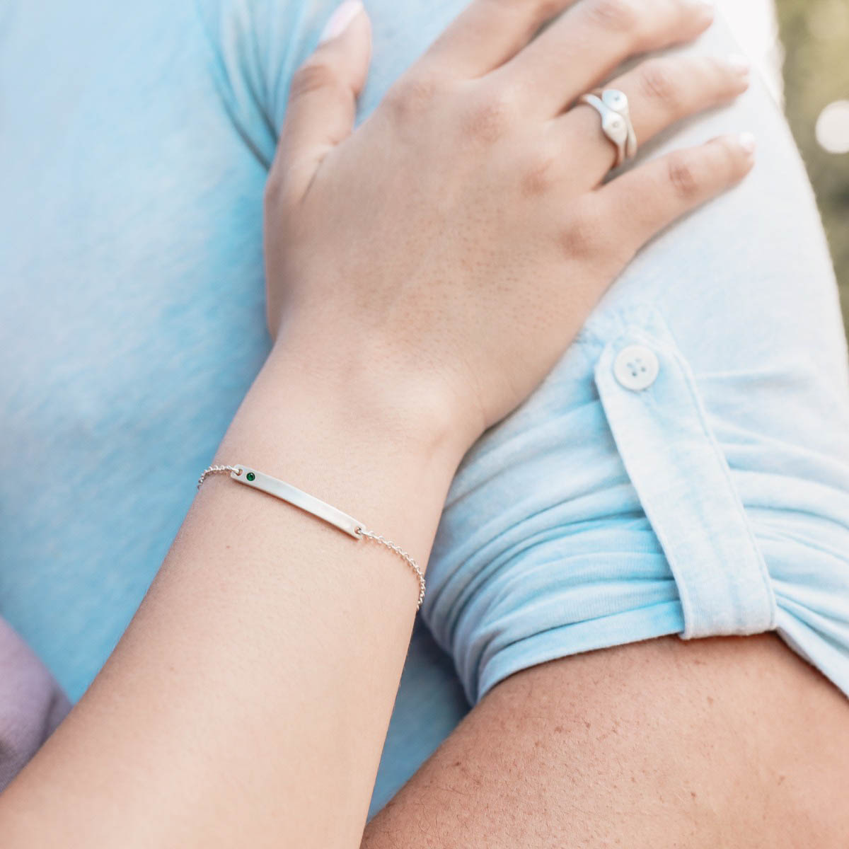 Woman displaying her cross bar birthstone bracelet sterling silver