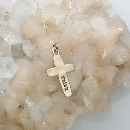 Handcrafted 14k yellow gold cross of faith necklace strung on a gold-filled link chain with "faith" stamped on the back